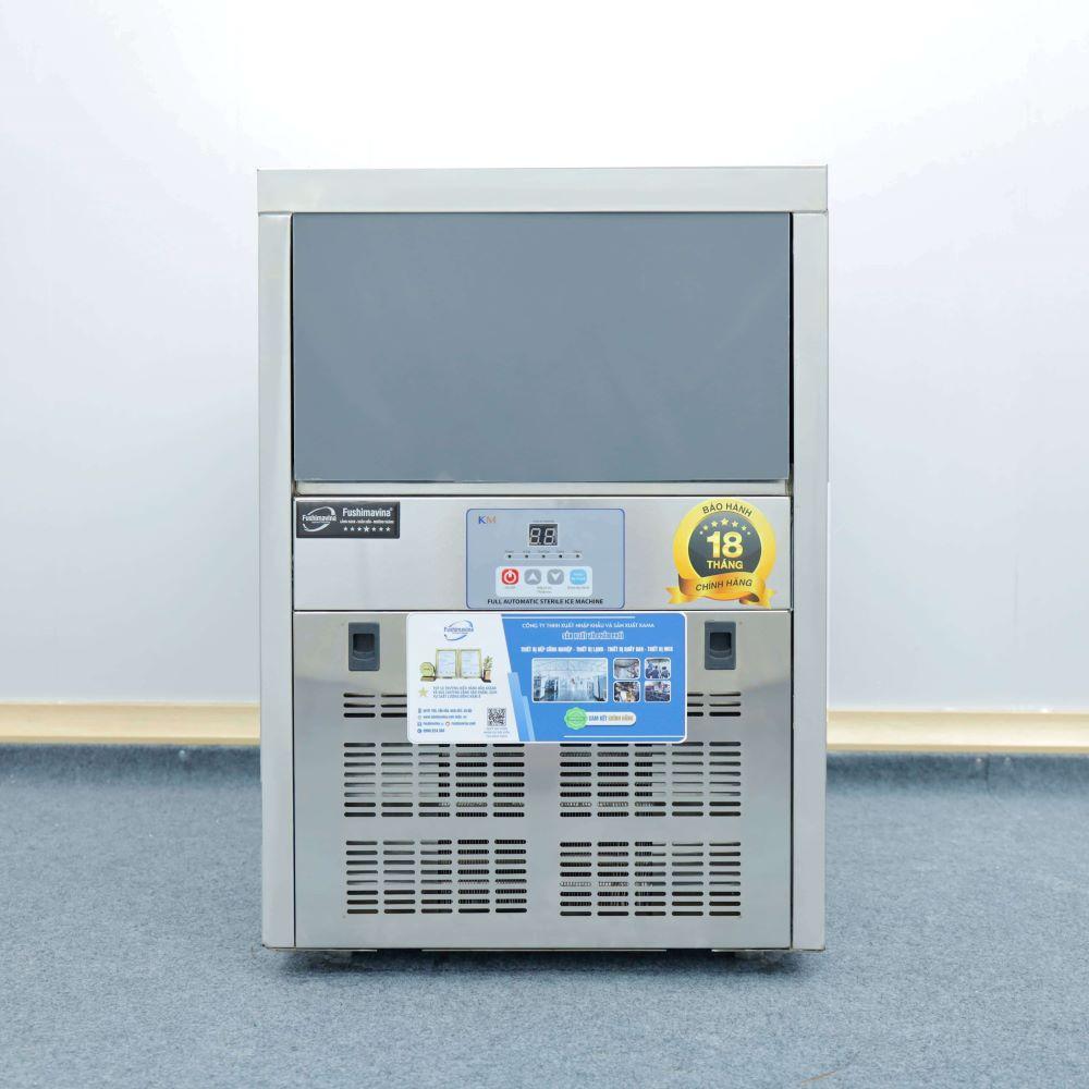 Một kỹ thuật viên đang kiểm tra bảng điều khiển thông minh của máy làm đá viên 80kg, thể hiện công nghệ tiên tiến.