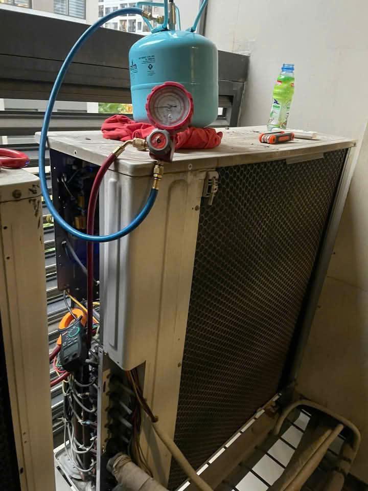 Một kỹ thuật viên đang chuẩn đoán lỗi trên hệ thống điều hòa trung tâm Daikin VRV bằng đồng hồ đo áp suất gas và thiết bị kiểm tra điện áp, trong bối cảnh dàn nóng ngoài trời