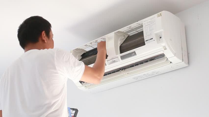 Kỹ thuật viên đang kiểm tra và siết chặt các ốc vít của dàn nóng điều hòa kêu to, minh họa lỗi lắp đặt sai.