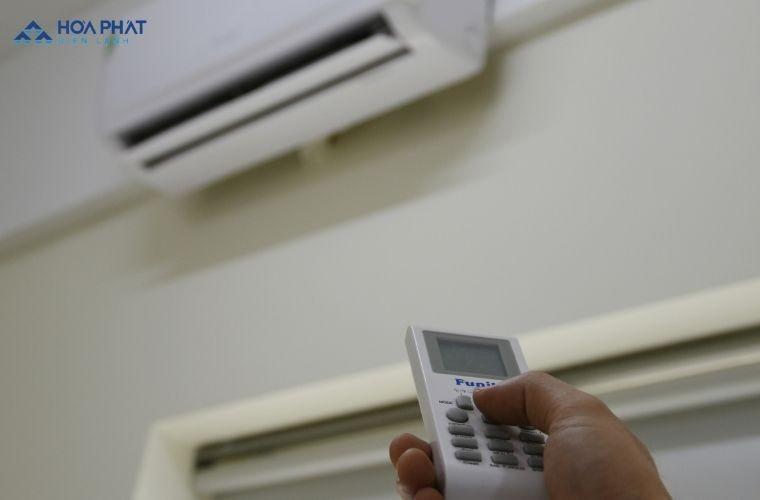 Hình ảnh một người thợ sửa chữa điều hòa đang kiểm tra remote điều khiển hoặc bộ phận nhận tín hiệu của điều hòa